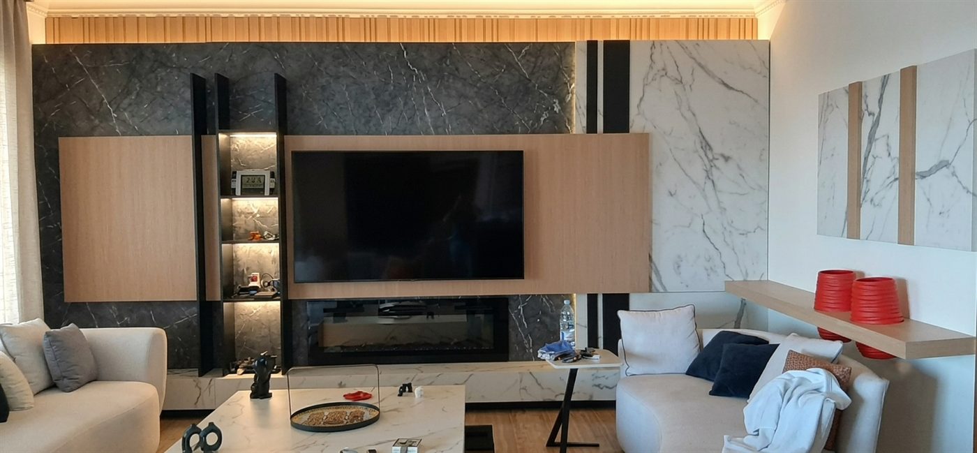 Living room TV wall in marble and backlit timber