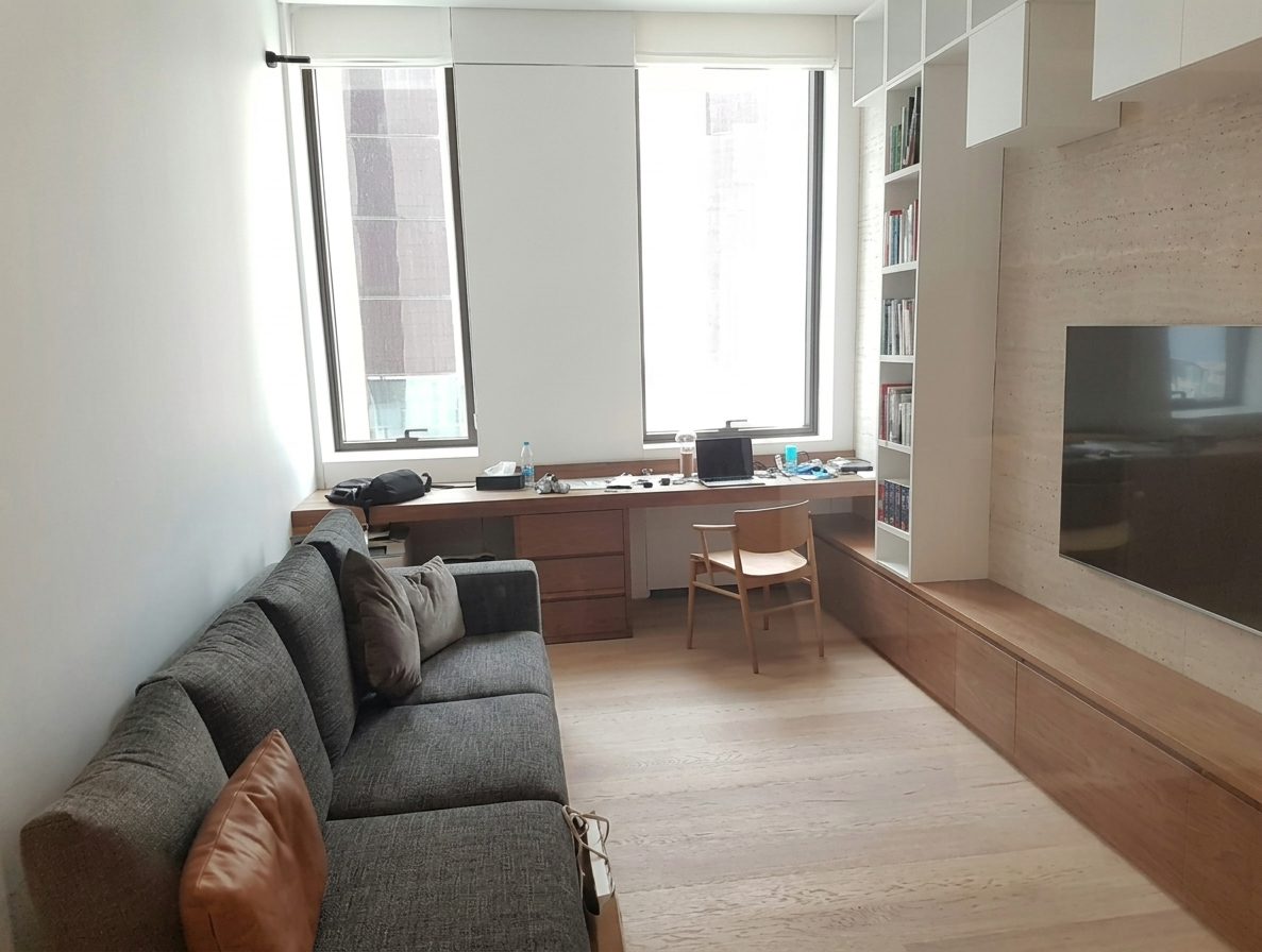 TV room with built-in oak desk, shelving and a low sofa
