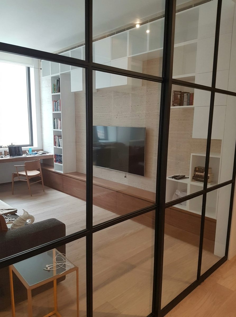 Black steel-framed glazed partition to the TV room