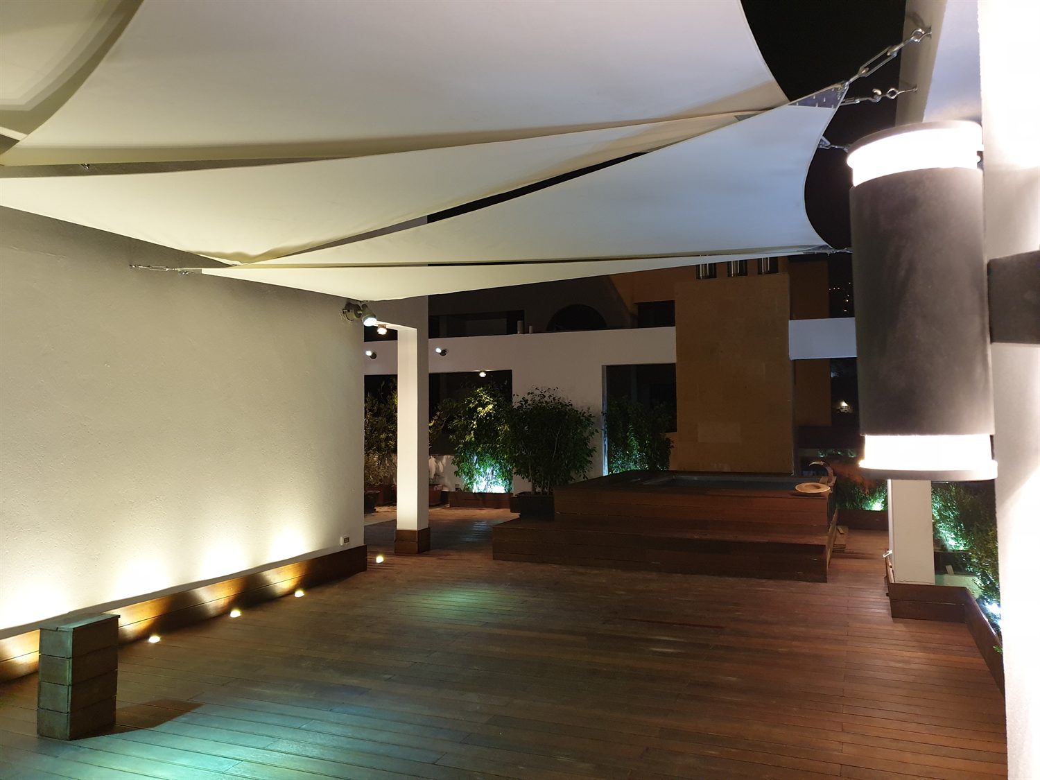 The deck at night, lit from the perimeter planting