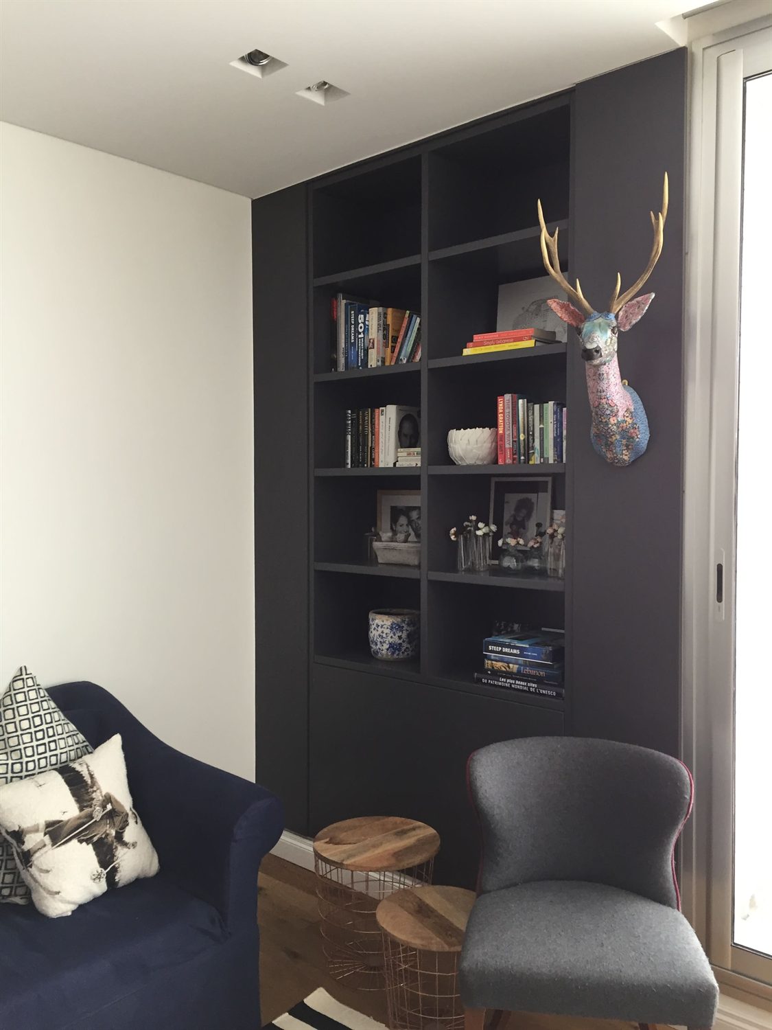Study with dark built-in shelving and a reading chair