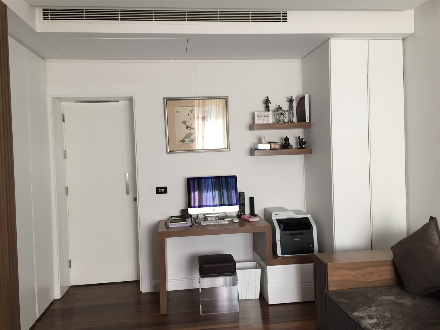 Desk nook with floating shelves and a fitted cabinet