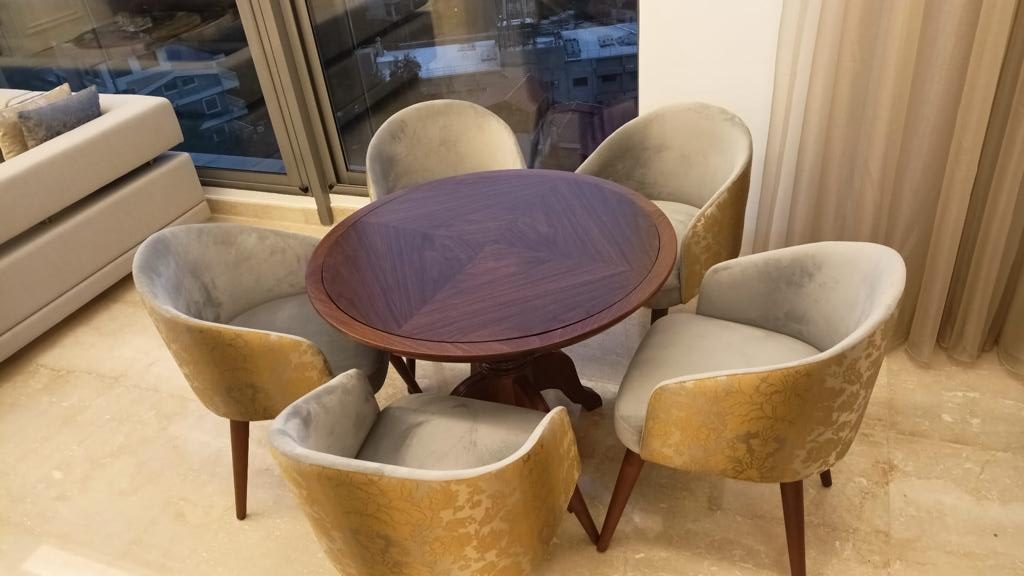 Round timber breakfast table with upholstered tub chairs